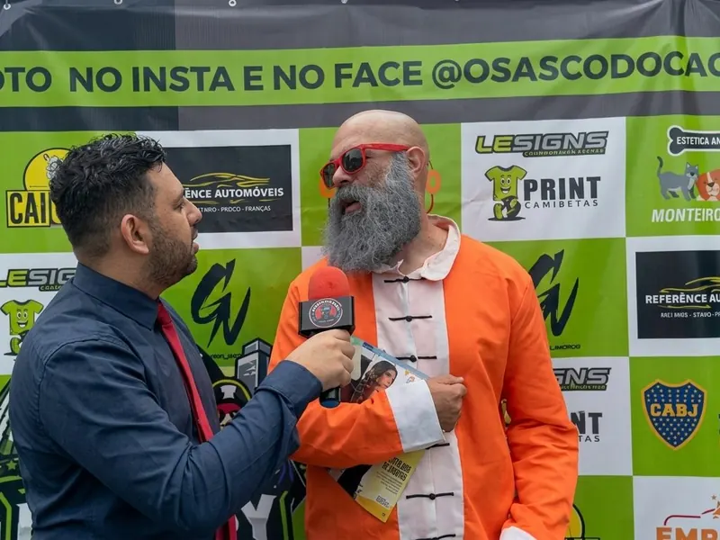 Entrevista no backdrop com o personagem de macacão laranja