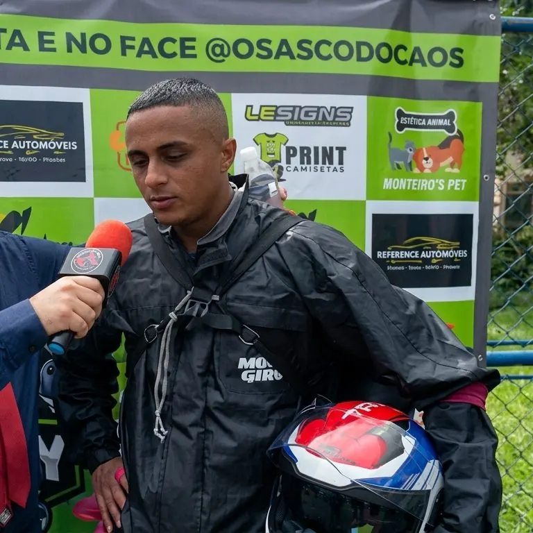 O motociclista de capacete na mão